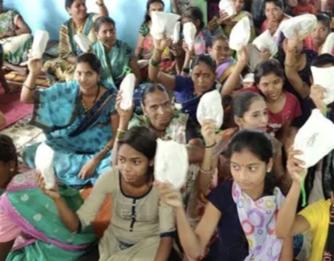 Women and girls holding up menstrual cups distributed by BleedBOLD